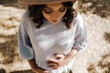 Woman thoughtfully holding her abdomen, symbolizing endometriosis support
