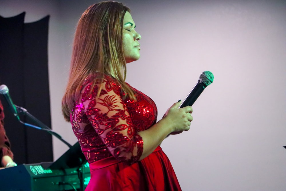 woman in red and white floral dress holding microphone