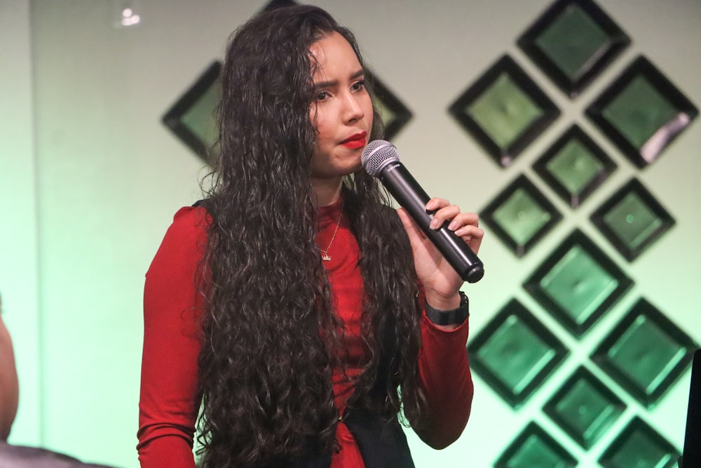 woman in red long sleeve shirt holding microphone