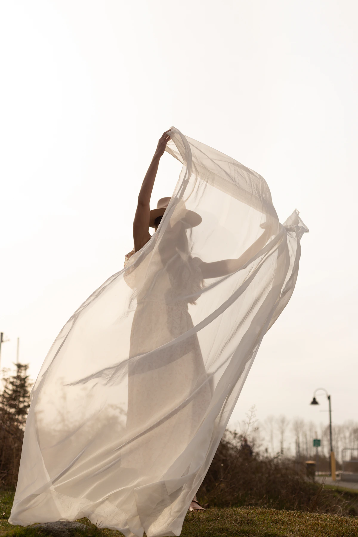 Bohemian bride behind a sheer wind-blown veil in soft light, Missoula Montana bridal boutique