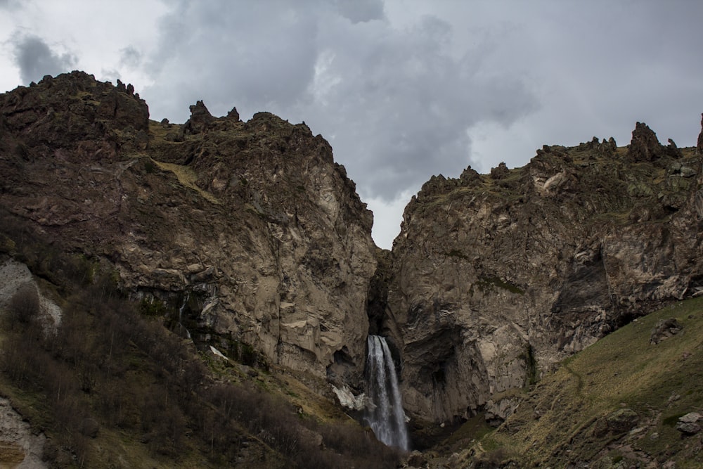 cascadas en medio de la montaña rocosa bajo el cielo blanco nublado durante el día