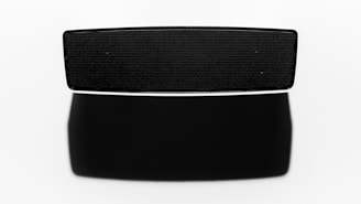 Close-up of a sleek matte black wireless speaker on a white background.