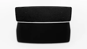 Close-up of the sleek black and gold bluetooth speaker glowing softly against a dark background