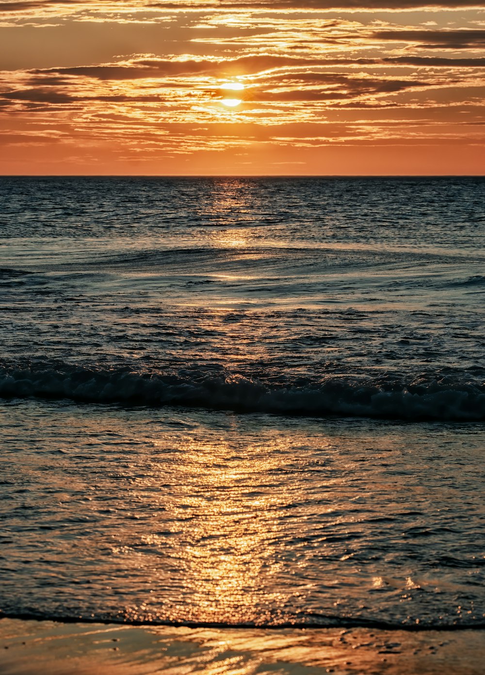 ocean waves crashing on shore during sunset