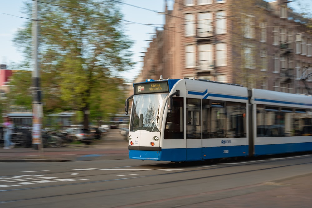 blue and white tram on road during daytime