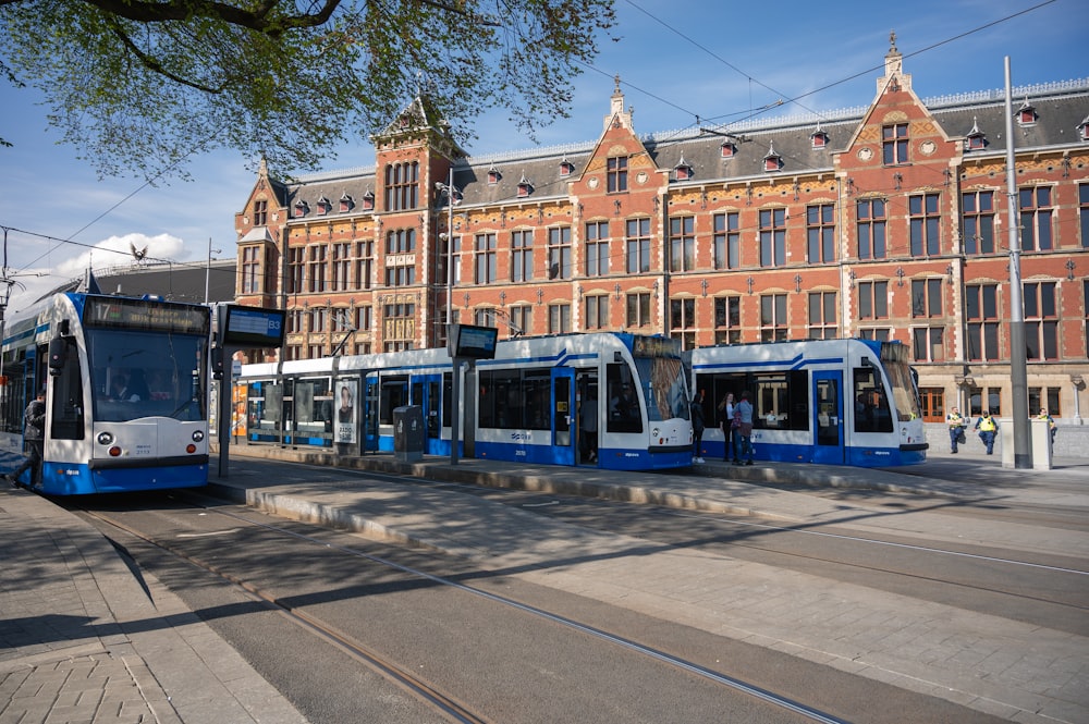 blue and yellow tram on road near brown building during daytime