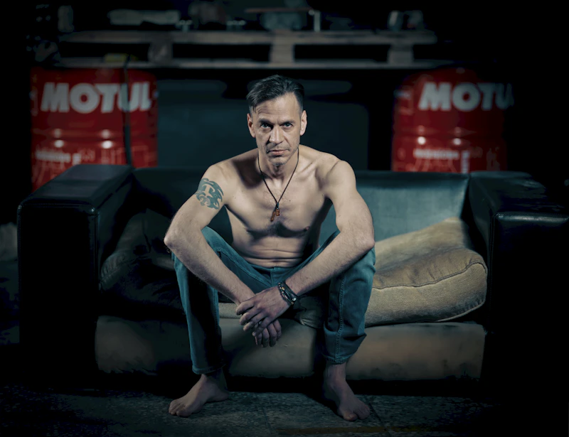 Shirtless man on couch, relaxed and approachable