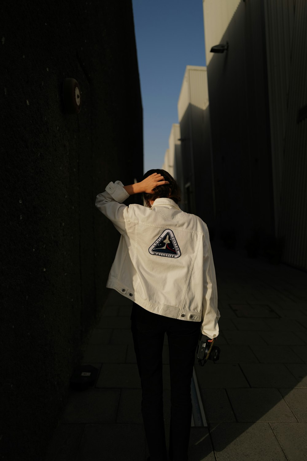 man in white hoodie standing near wall