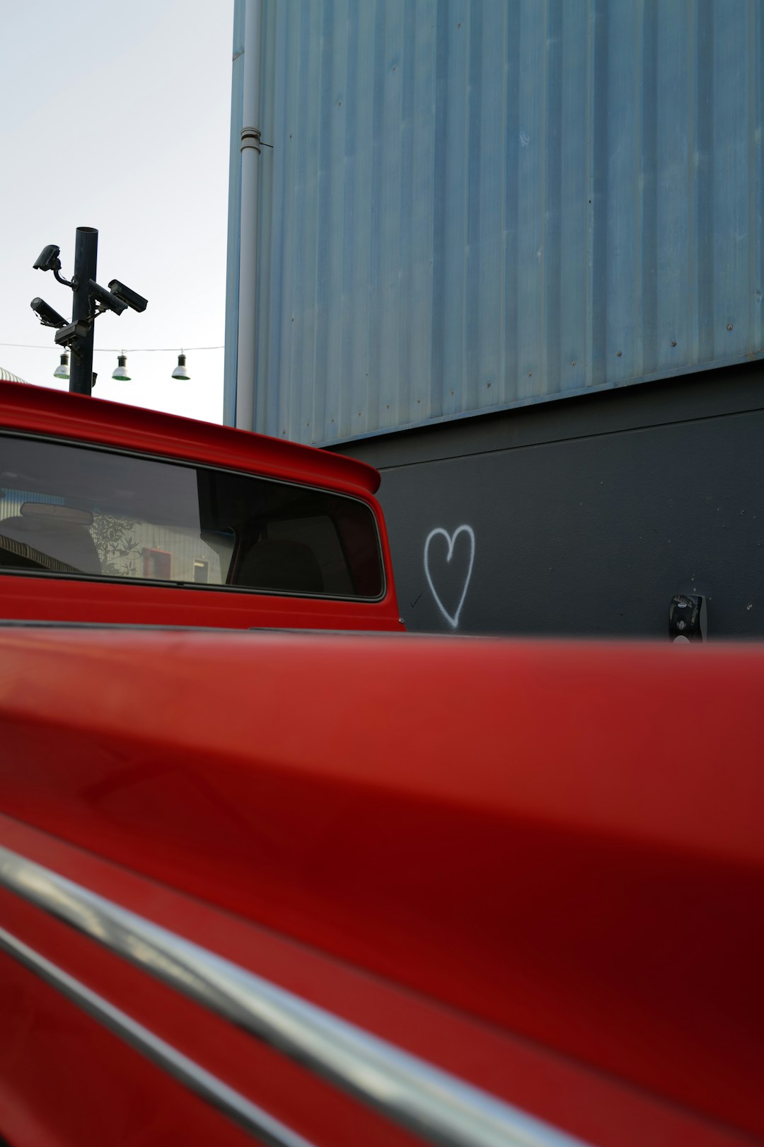 red car in front of white building