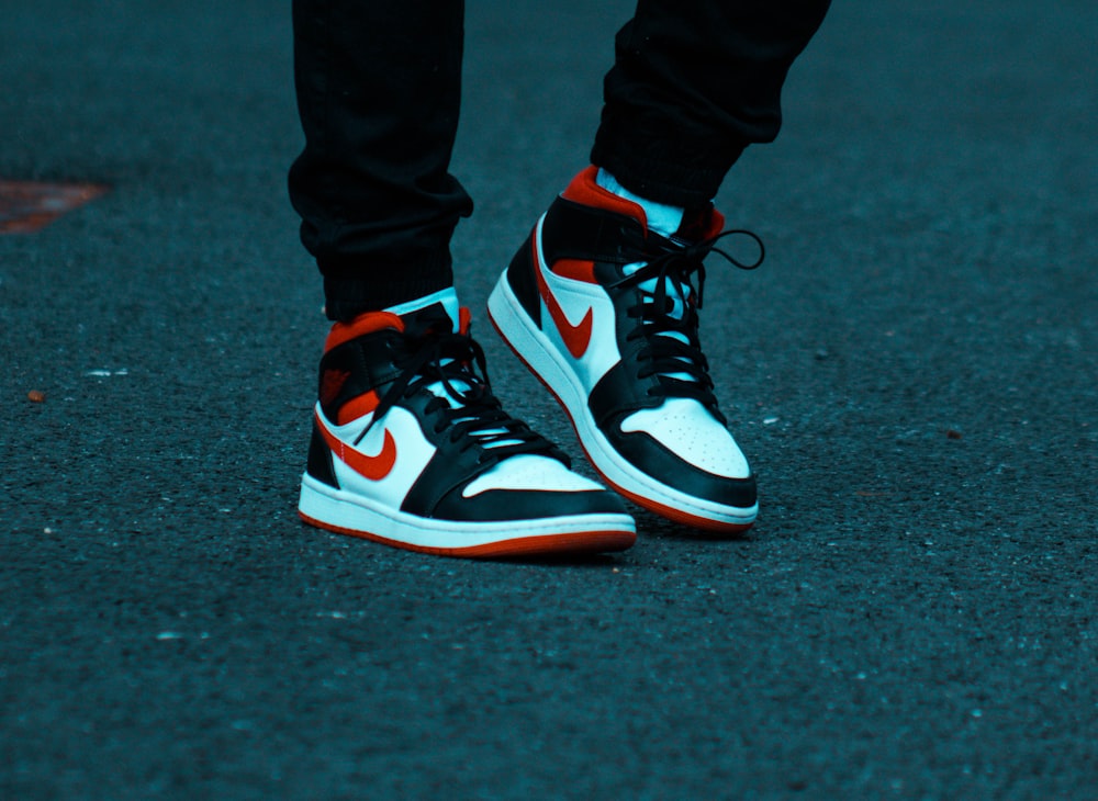 person in black white and red nike sneakers photo – Free Clothing Image on  Unsplash