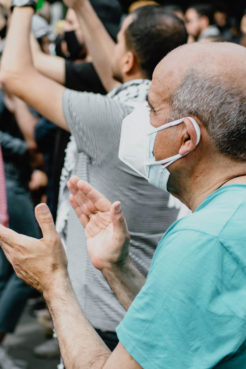 man in blue scrub shirt wearing white face mask