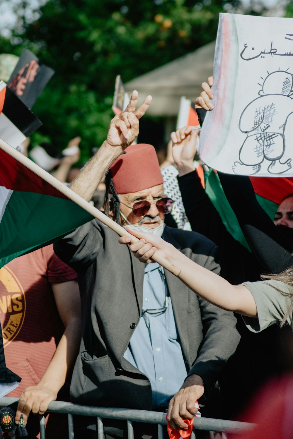 homme en chapeau blanc et rouge tenant un drapeau