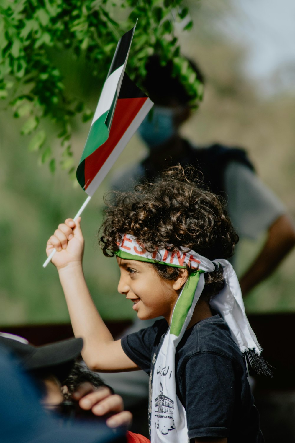 boy in blue and white shirt holding flag of us a during daytime