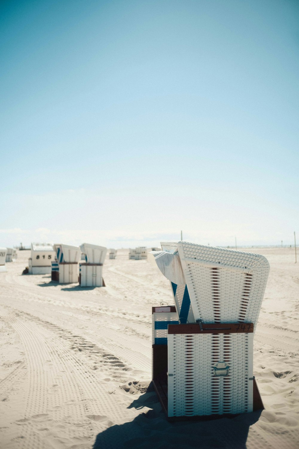 white and red wooden houses on white sand during daytime