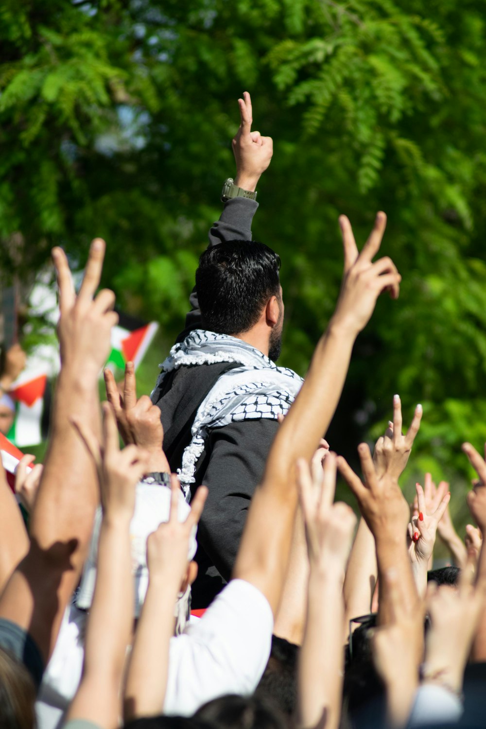 man in black and white shirt raising his hands
