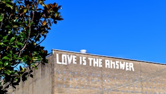 a brick building with the words love is the answer painted on it