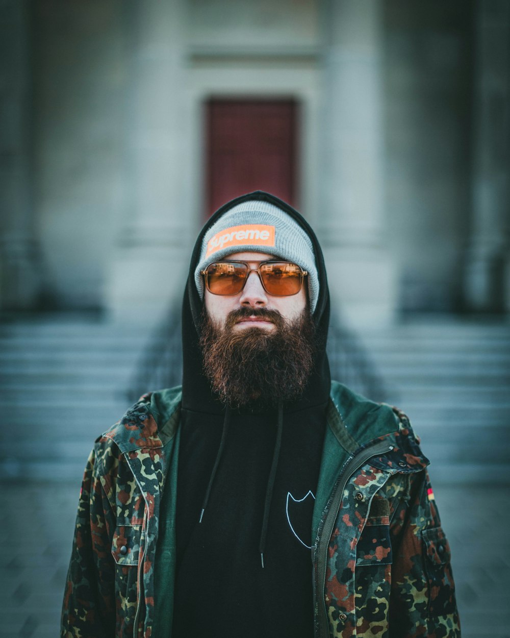 man in black and green hoodie wearing black sunglasses