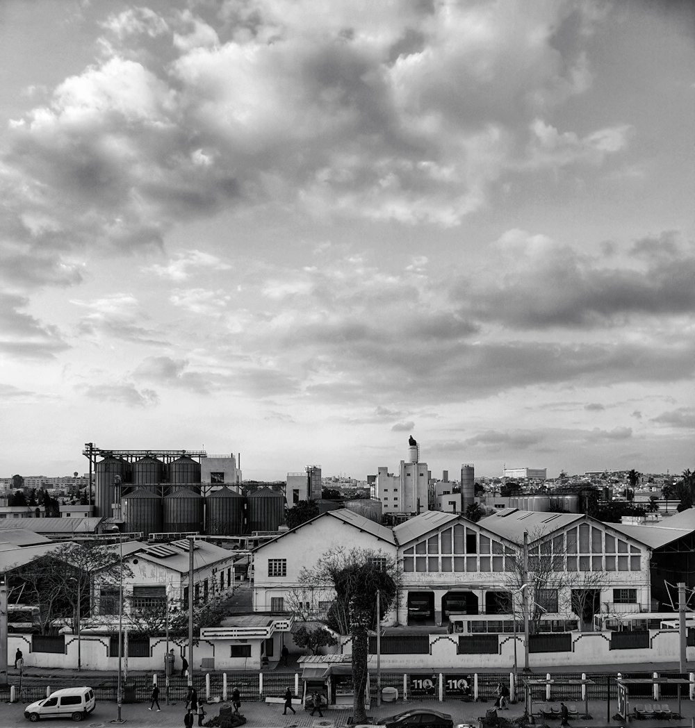 grayscale photo of houses under cloudy sky