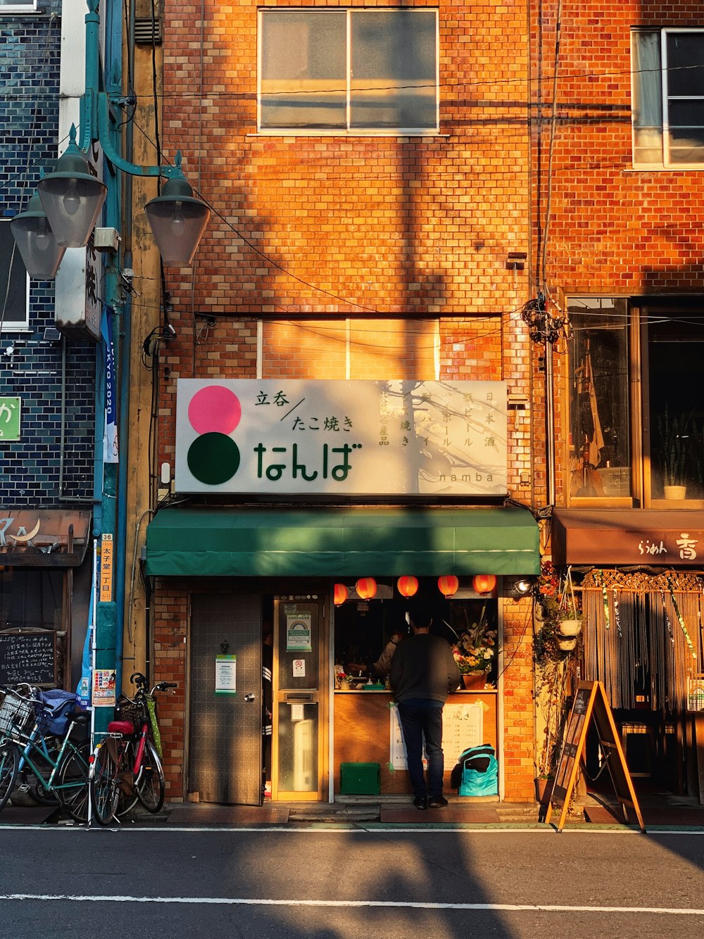 brown brick building with white and green signage