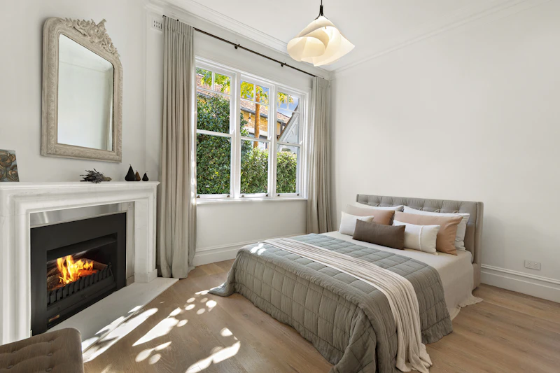 Guest bedroom with fireplace and bright window