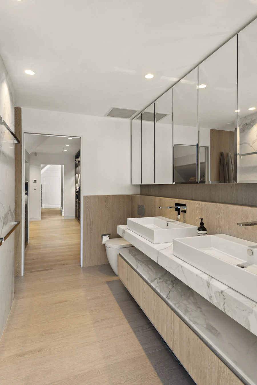 Baño con doble lavabo y espejo alargado
