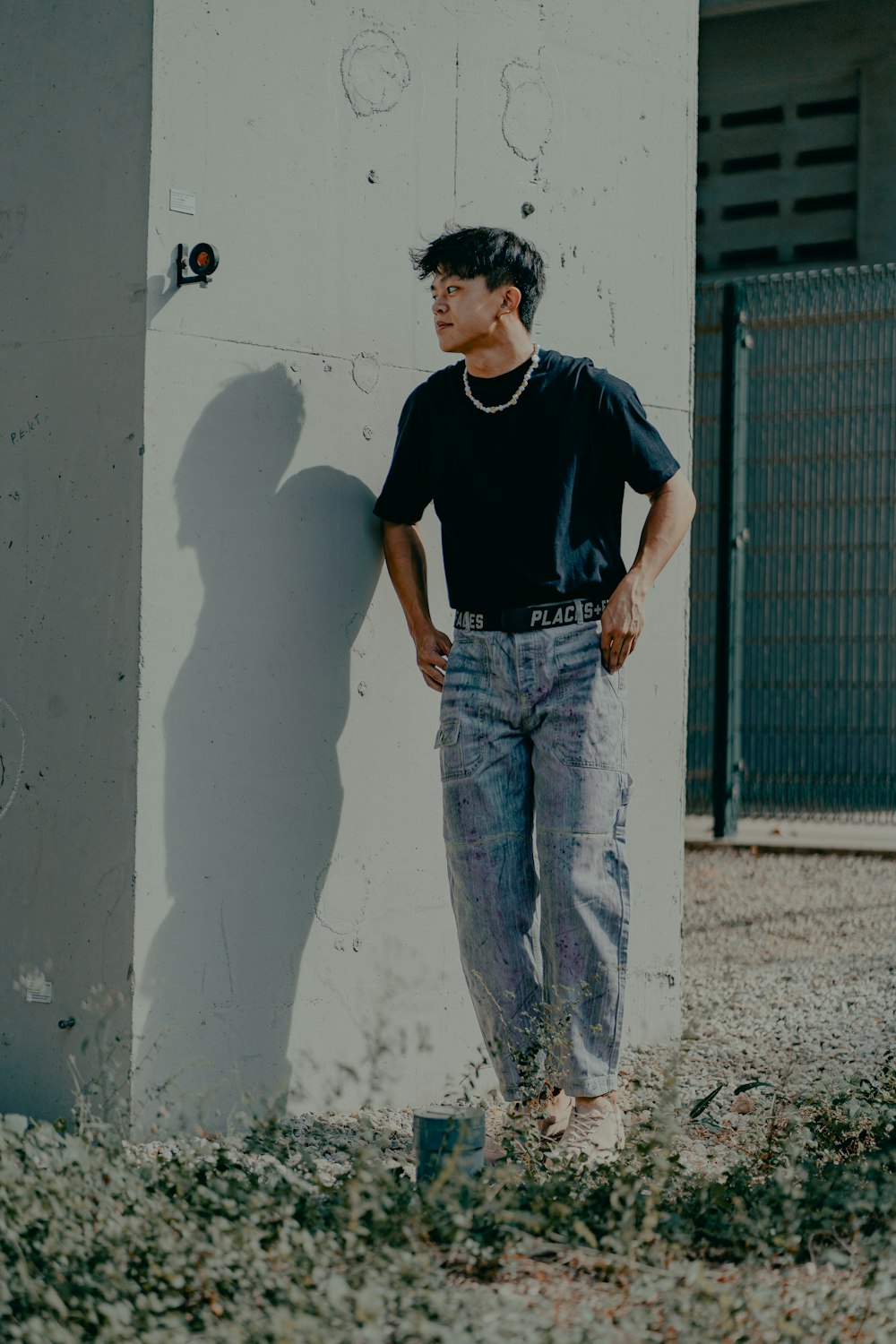 man in black crew neck t-shirt and blue denim jeans standing beside white  wall during photo – Free Clothing Image on Unsplash