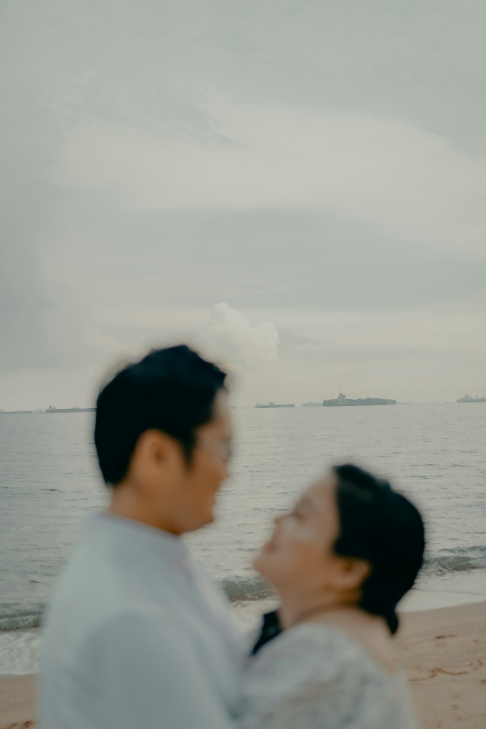 man and woman kissing near body of water during daytime