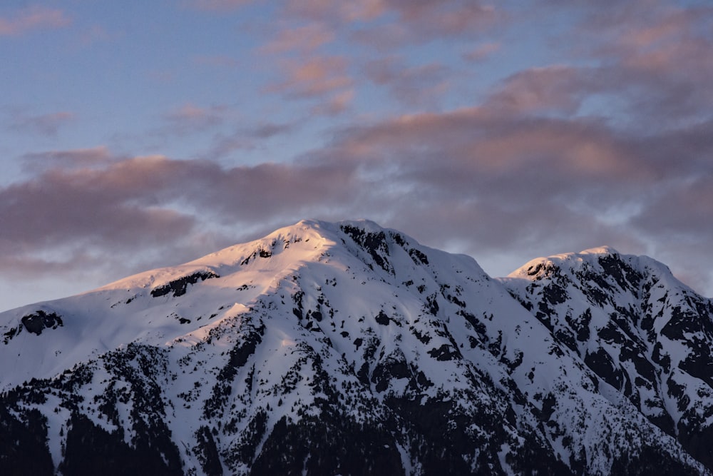 snow covered mountain under cloudy sky during daytime