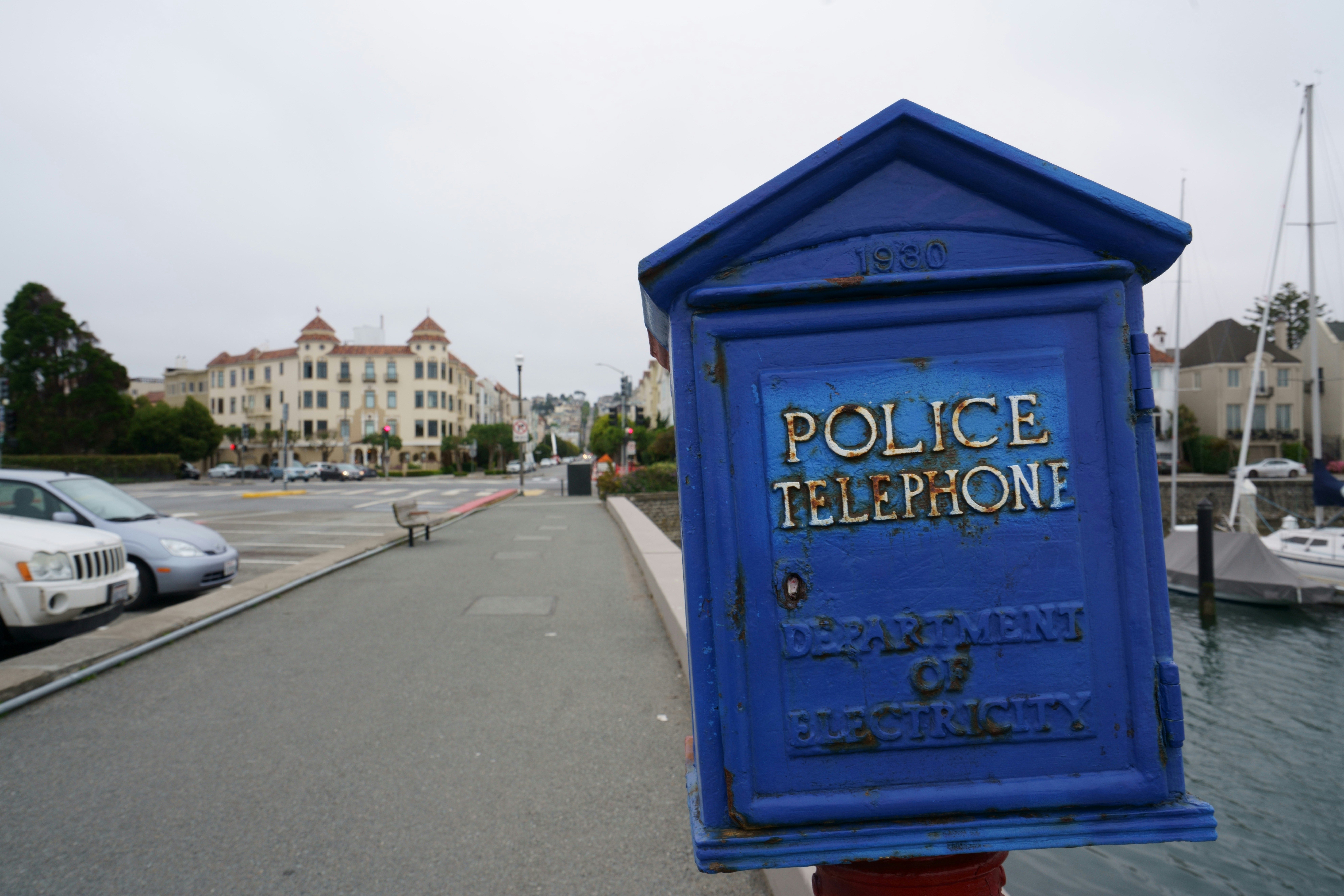 blue and white wooden signage on gray asphalt road during daytime
