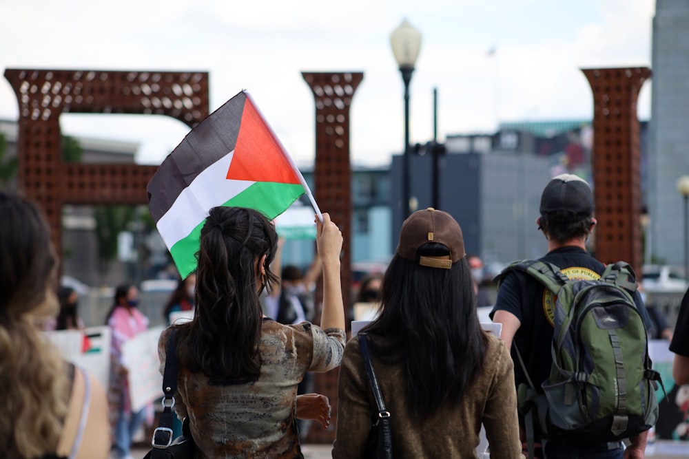 woman in brown jacket holding flag