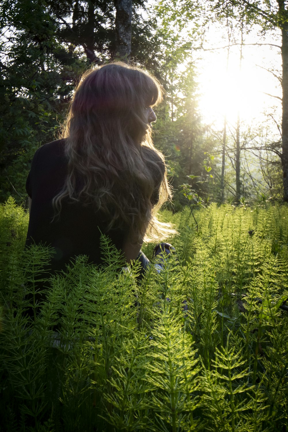 Mujer en chaqueta negra de pie en el campo de hierba verde durante el día