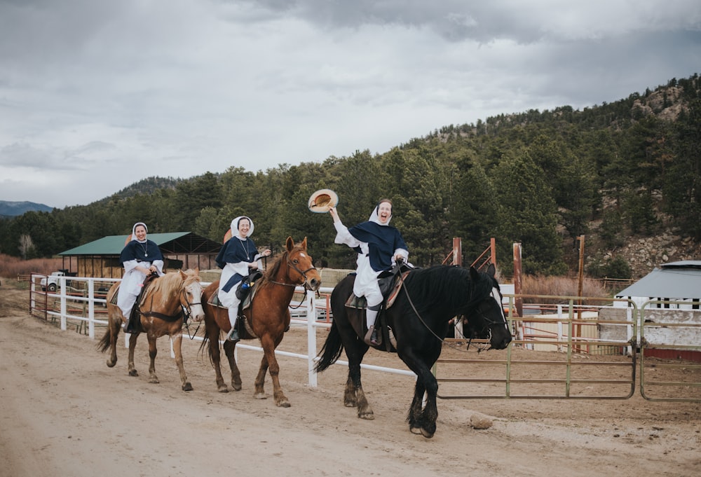 2 men riding horses on field during daytime