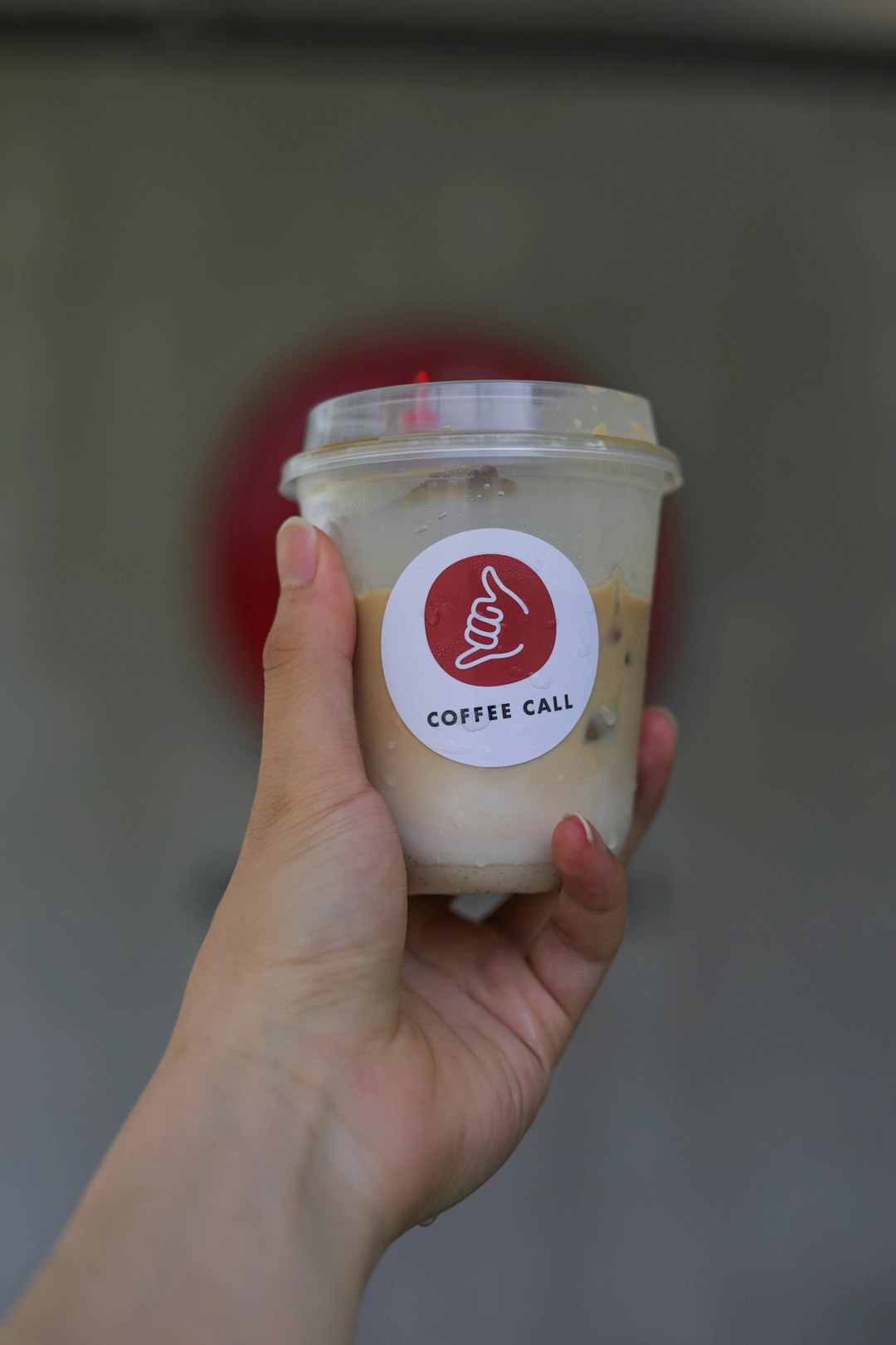 person holding white and red labeled jar