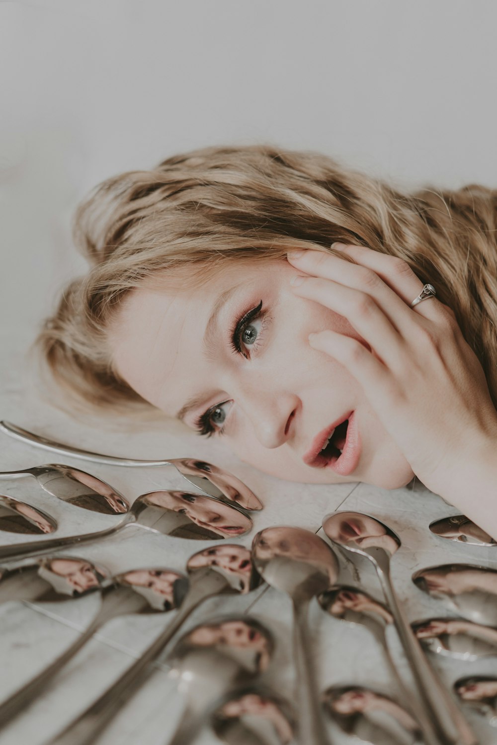 woman with red lipstick lying on white textile