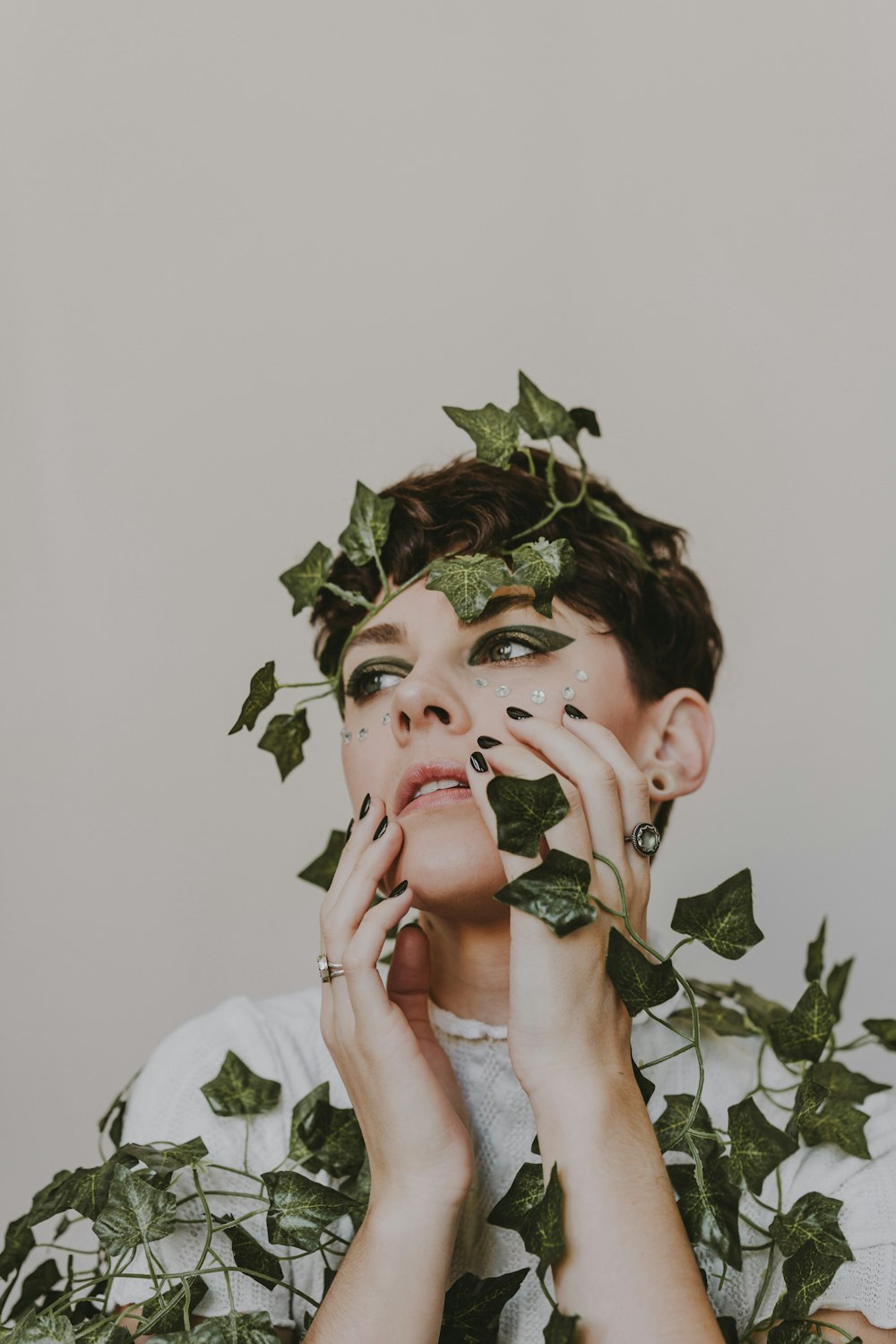 woman in white shirt holding green leaves