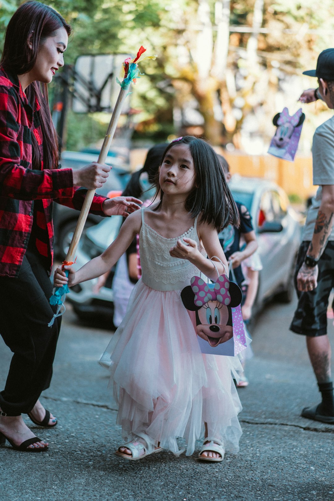 girl in white dress standing beside woman in red and black plaid dress