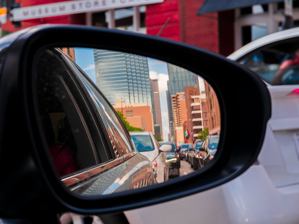 car side mirror showing cars parked on parking lot during daytime