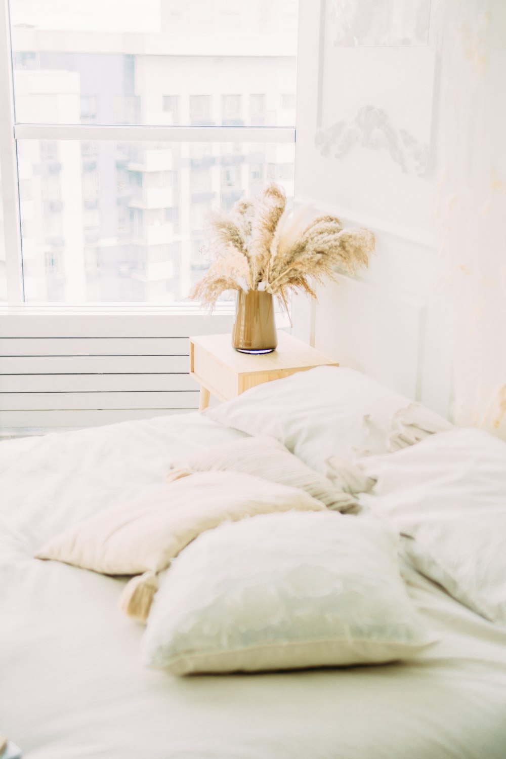 white bed linen near white window curtain