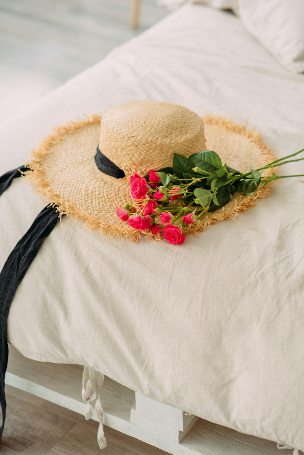 brown woven hat with red and green flower on white textile