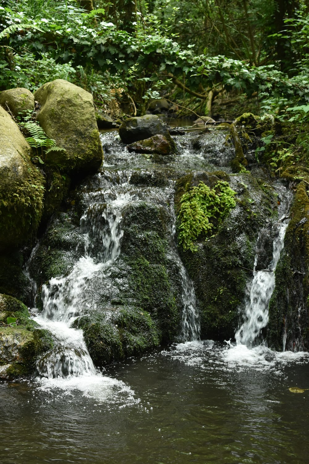 water falls on rocky shore during daytime