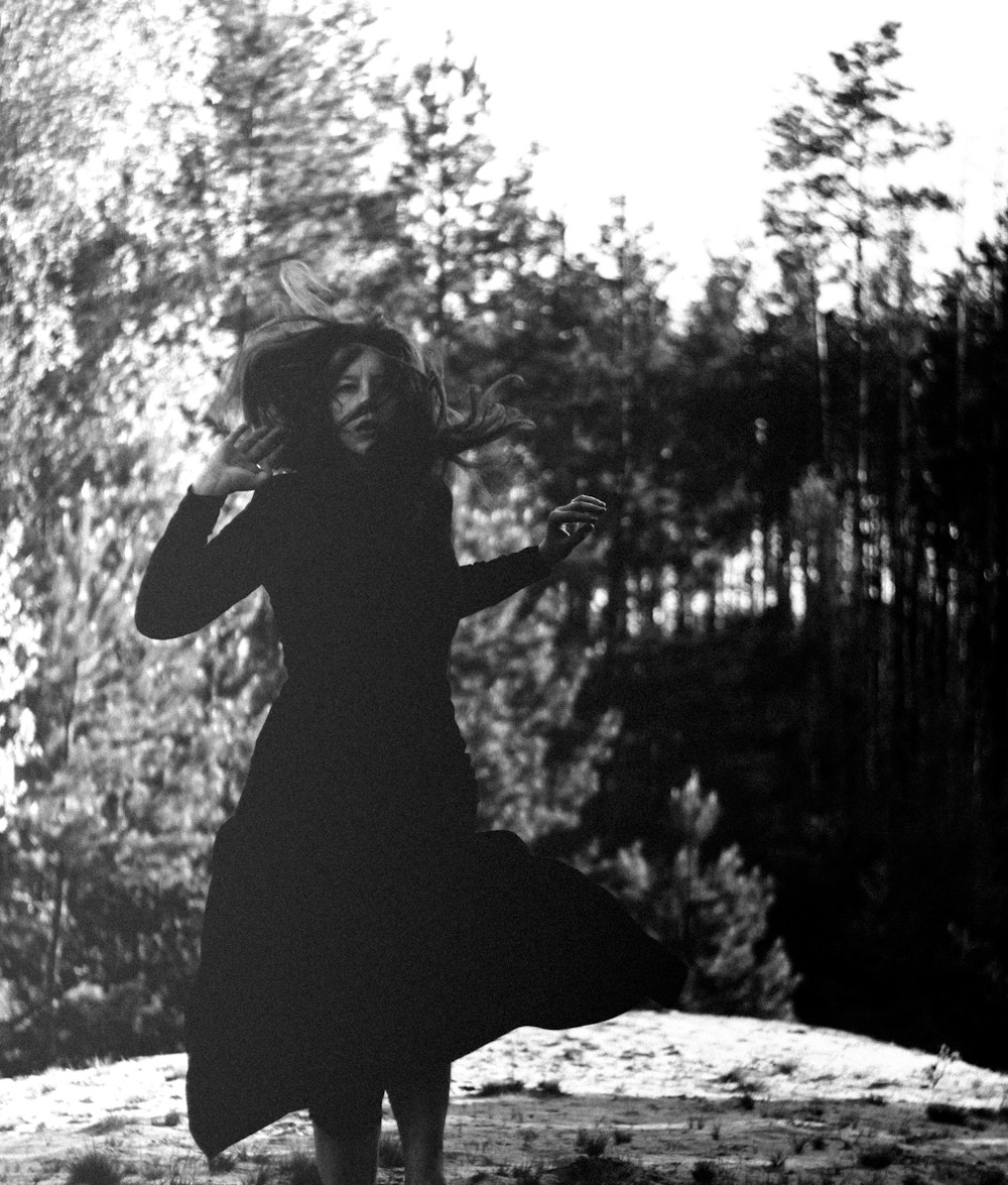 Frau in schwarzem Kleid sitzt auf Felsen