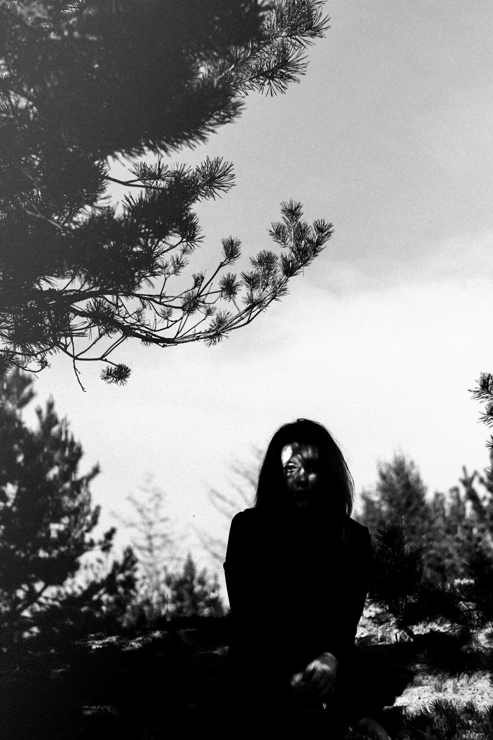 woman in black long sleeve shirt standing near bare trees during daytime