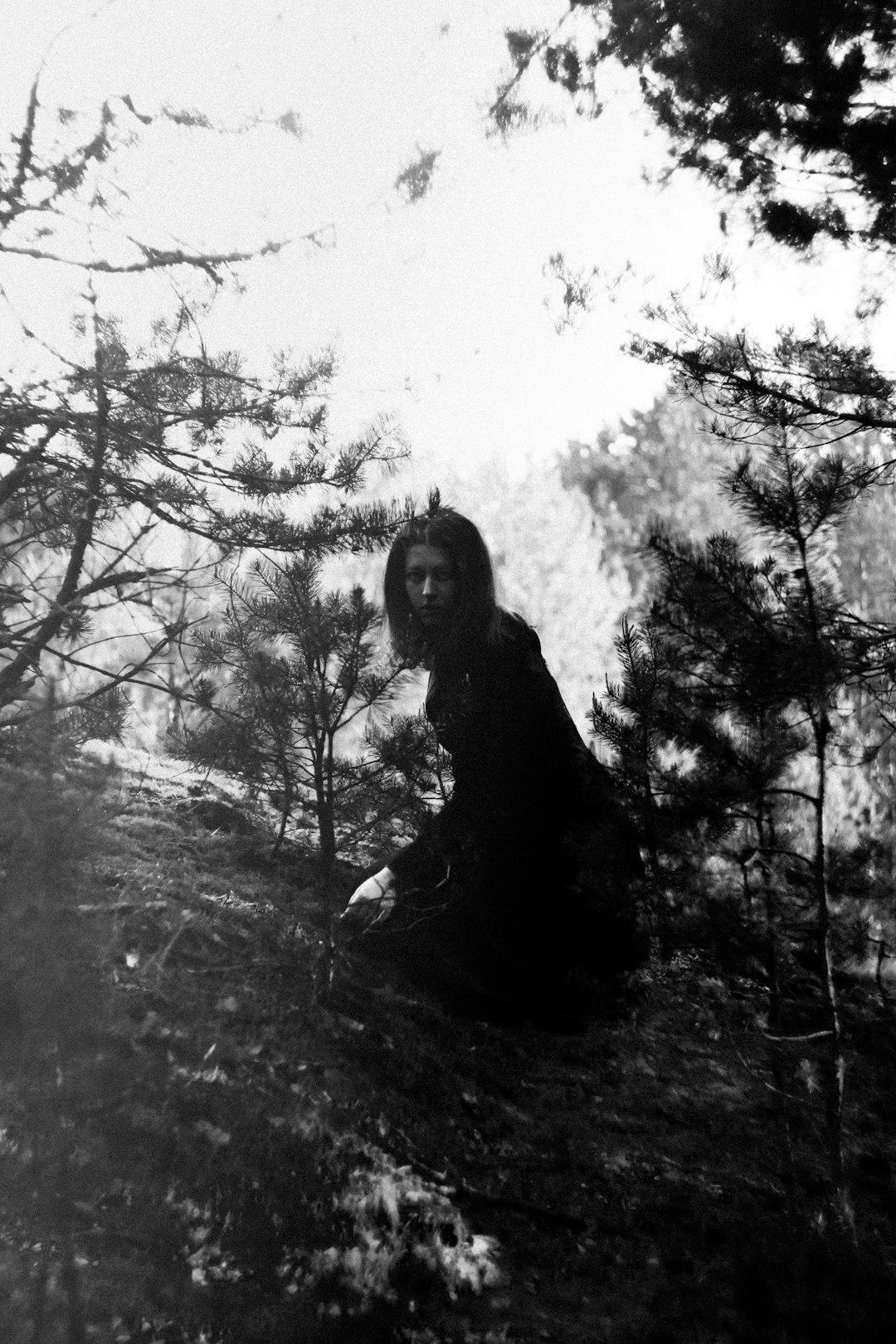 woman in black long sleeve shirt standing near trees