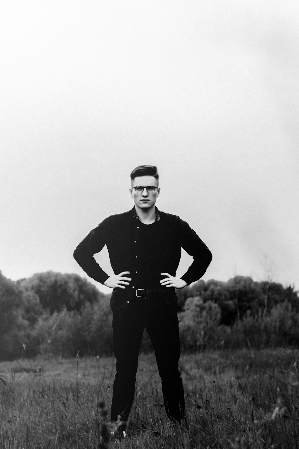 man in black long sleeve shirt standing on grass field