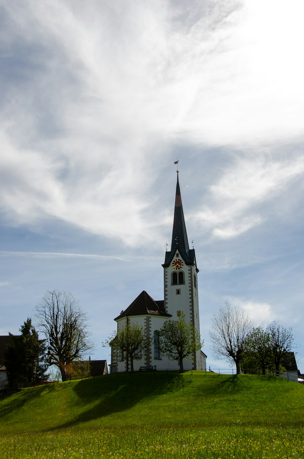 Bâtiment en béton blanc et noir sous des nuages blancs pendant la journée