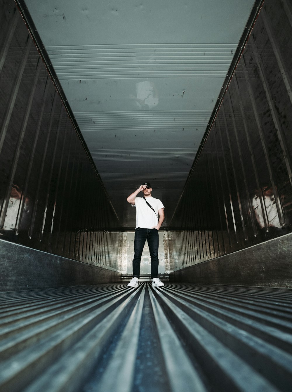 woman in white long sleeve shirt and black pants standing on tunnel