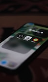 A close-up view of a smartphone screen displaying three app icons inside a folder labeled 'BLACK'. The visible apps are the Watch, Unsplash, and Fitness apps.