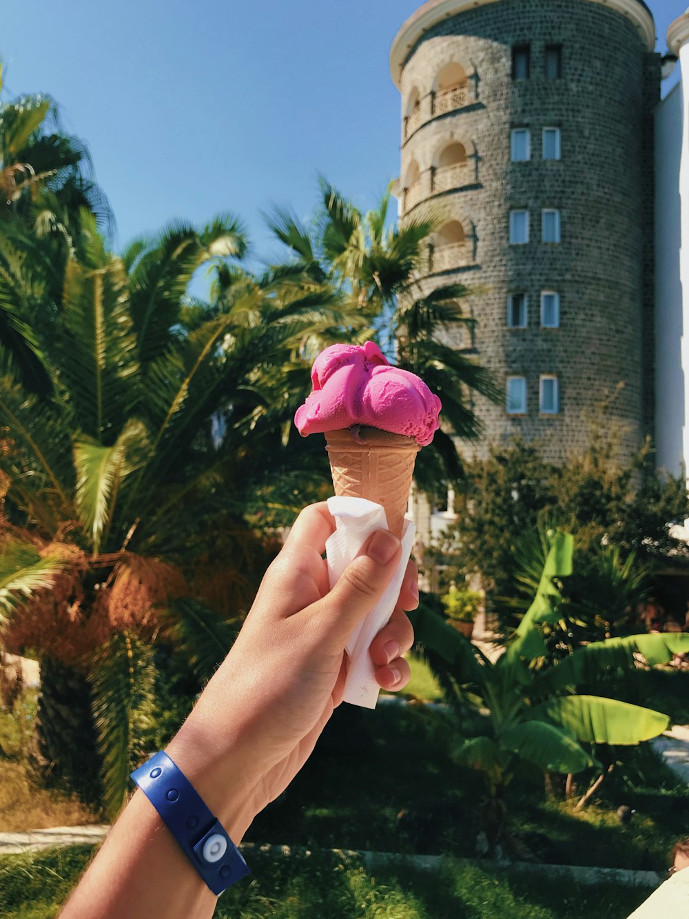Persona sosteniendo un cono de helado rosa