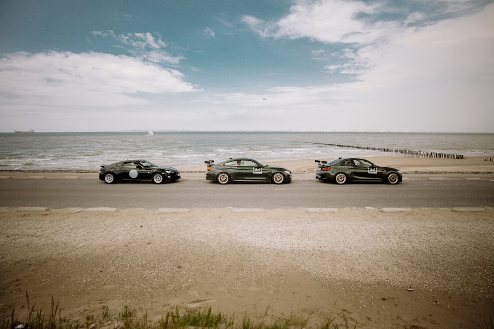 3 cars parked on beach shore during daytime