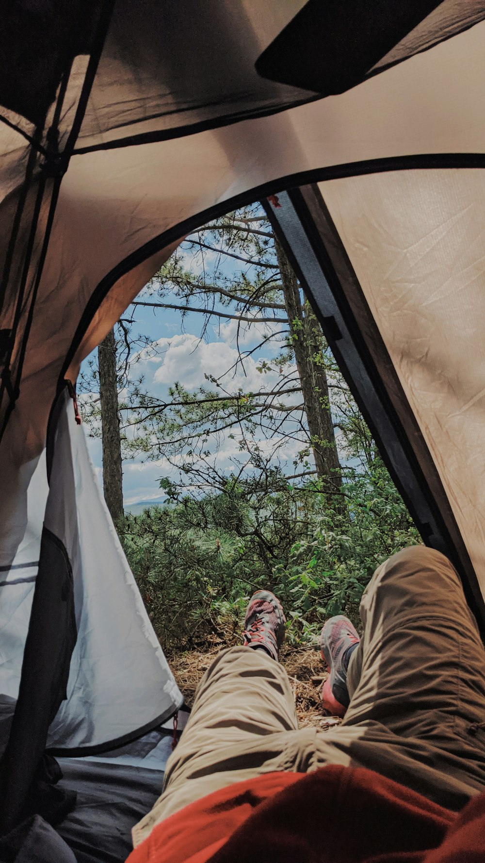 person in brown pants lying on bed